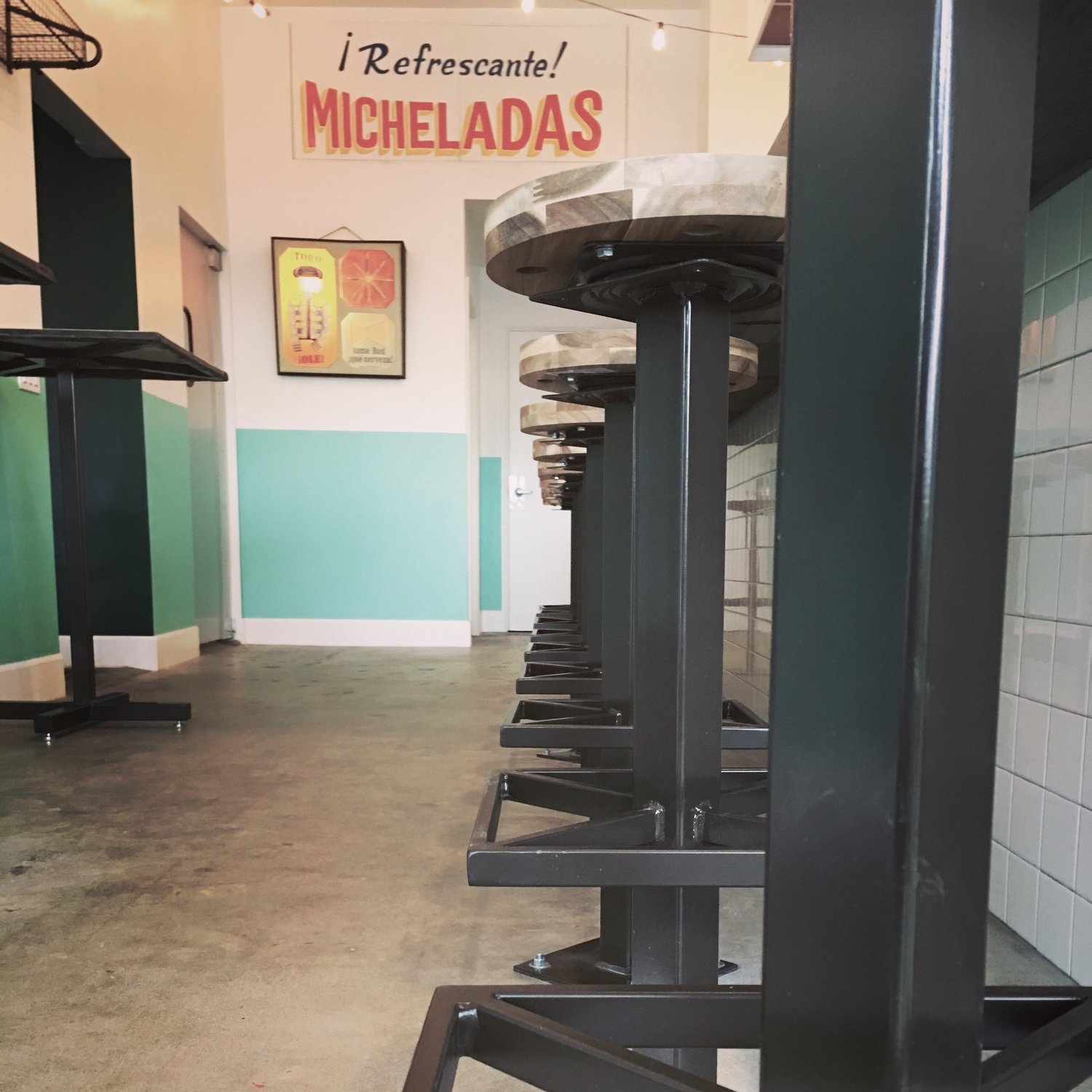 The Otro Día interior with turquoise accents and a micheladas sign