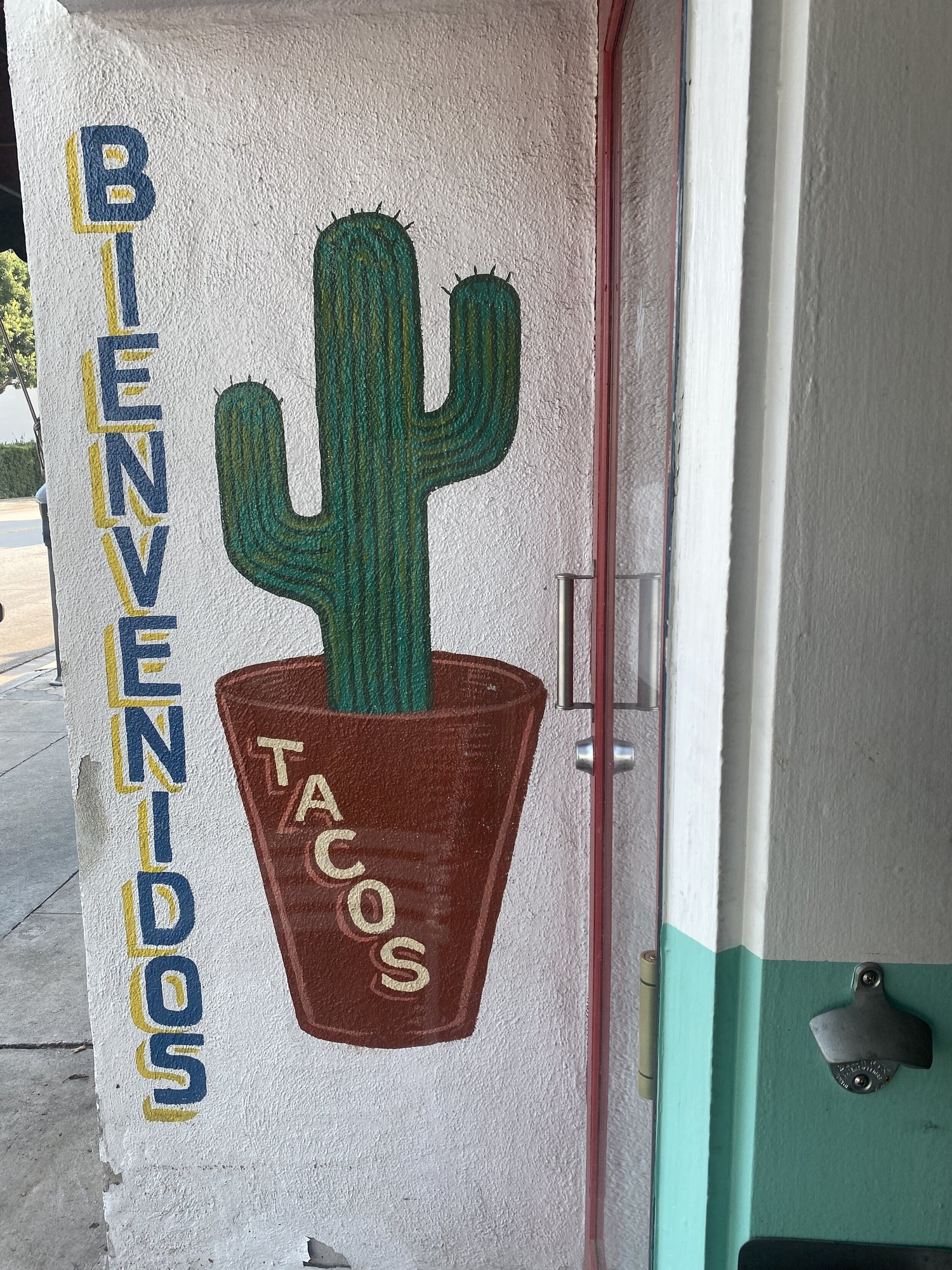 A painted cactus and welcome sign inside Otro Día